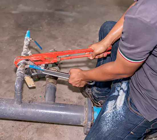 Licensed plumber repairing a copper pipe leak in a California basement